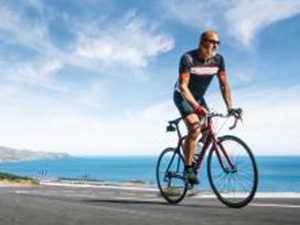 Mature Adult on a racing bike climbing the hill at mediterranean sea landscape coastal road : Stockfoto oder Stockvideo und Fotos, Bilder, Stockmedien von rcfotostock | RC-Photo-Stock