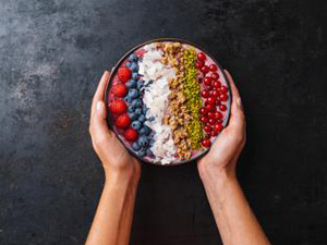 Woman hands hold a Healthy breakfast bowl, wirh blueberry smoothie with, raspberry, blueberrys, coconut, nuts and currants toppings : Stockfoto oder Stockvideo und Fotos, Bilder, Stockmedien von rcfotostock | RC-Photo-Stock